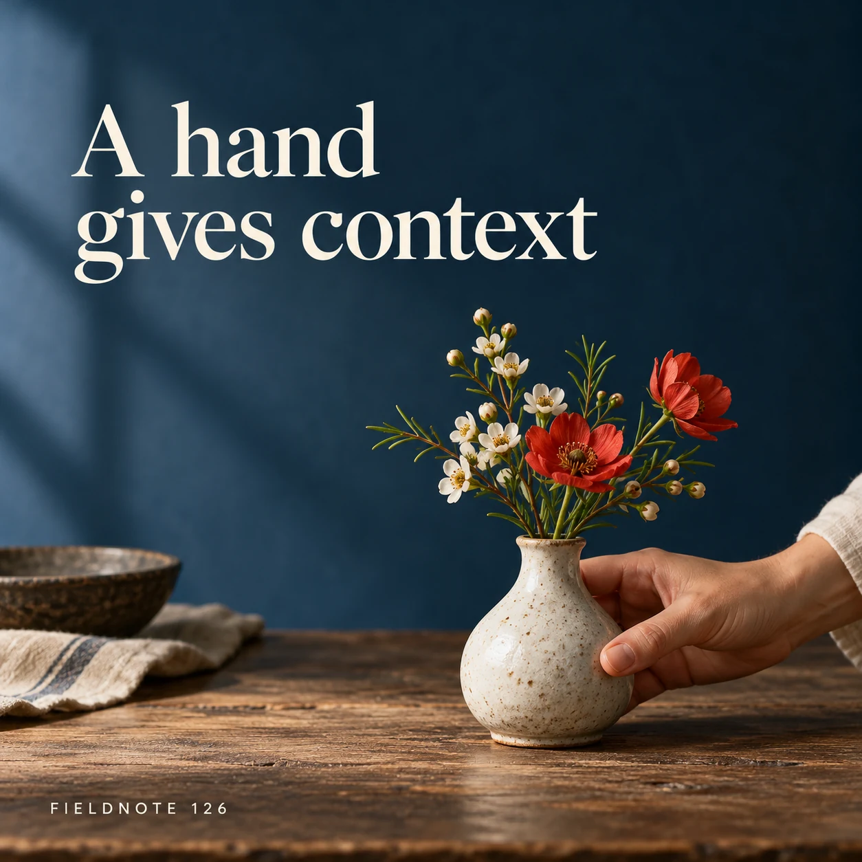 Illustrative campaign concept: adult hand gently holding a small ceramic vase, with the headline “A hand gives context” and fictional FIELDNOTE branding.