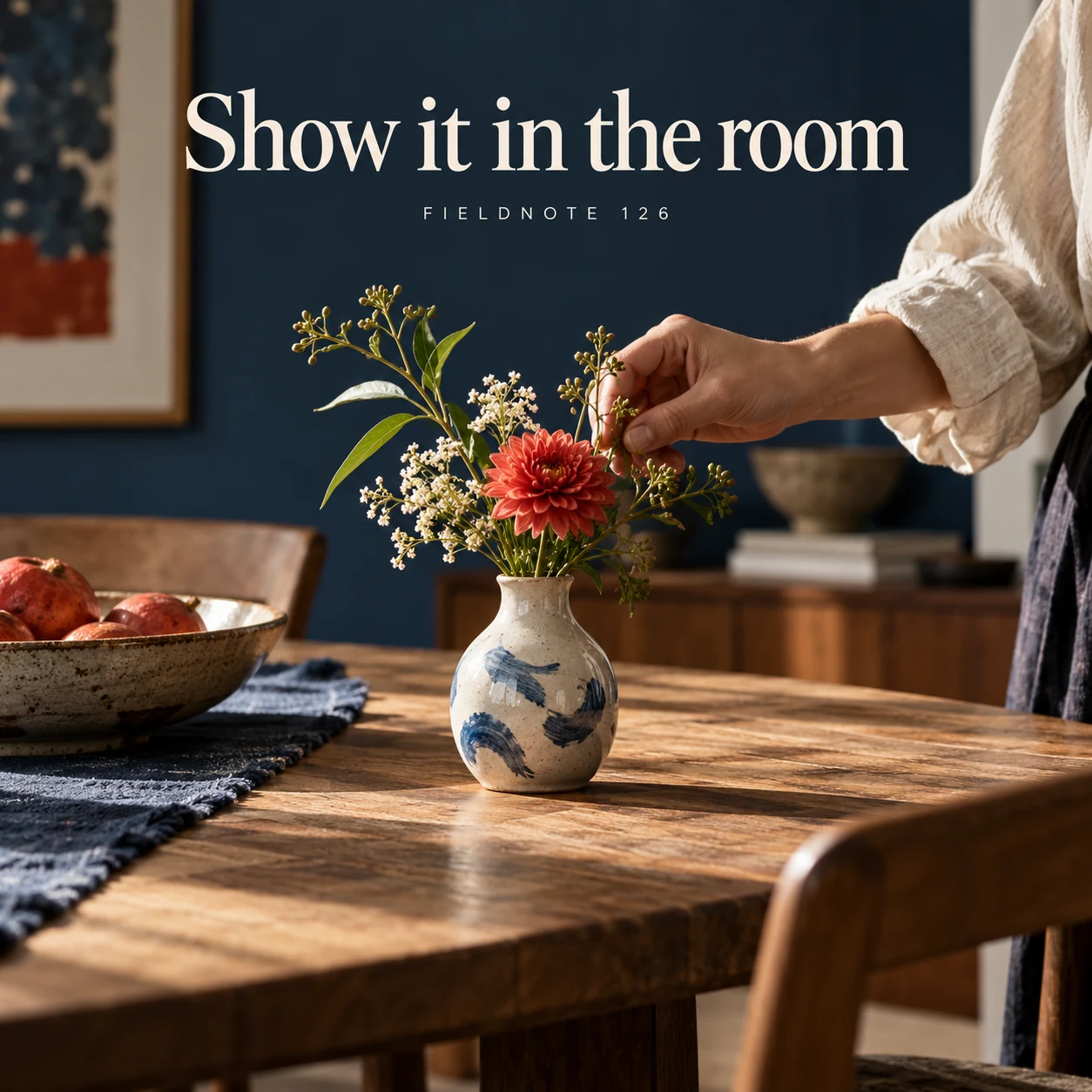 Illustrative campaign concept: small vase on a wide dining table, with the headline “Show it in the room” and fictional FIELDNOTE branding.